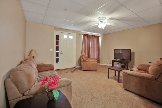 carpeted living room featuring ceiling fan and a drop ceiling