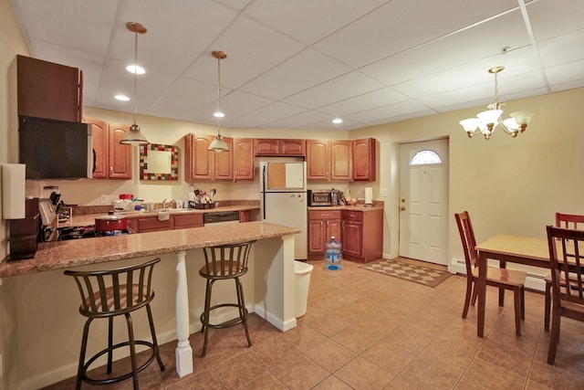 kitchen featuring light stone counters, dishwasher, white refrigerator, kitchen peninsula, and hanging light fixtures