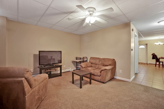 carpeted living room featuring ceiling fan with notable chandelier and a drop ceiling