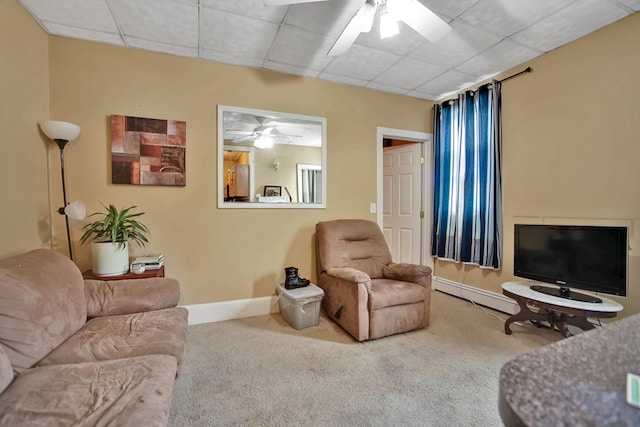 carpeted living room with ceiling fan, a drop ceiling, and a baseboard radiator