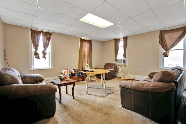 living room with a drop ceiling, carpet flooring, and cooling unit