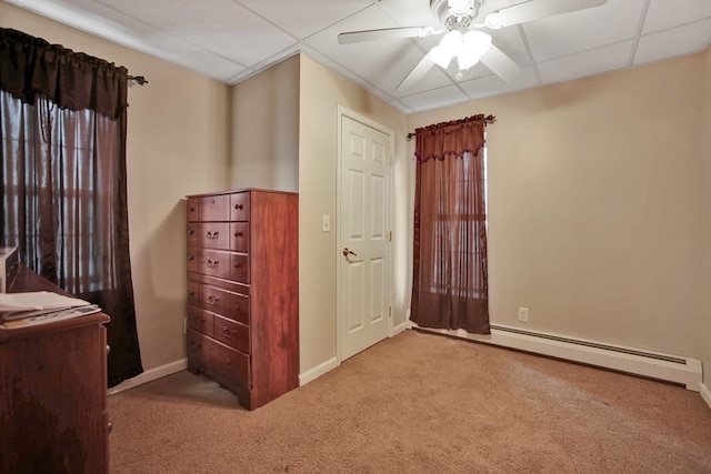 carpeted bedroom with a baseboard radiator, ceiling fan, and a drop ceiling