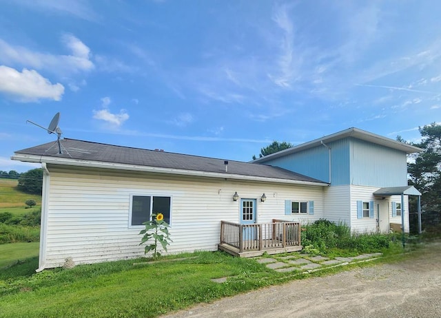 back of house featuring a wooden deck and a yard