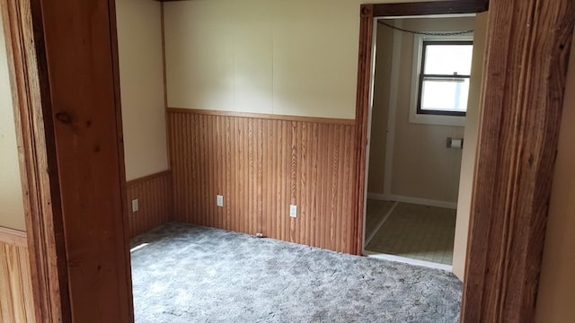 unfurnished bedroom with wood walls and carpet