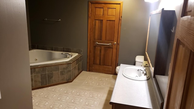 bathroom with vanity, tiled bath, and toilet