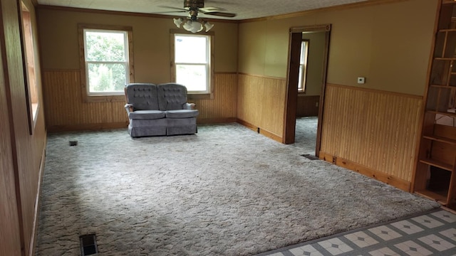 sitting room featuring ceiling fan, light carpet, and ornamental molding