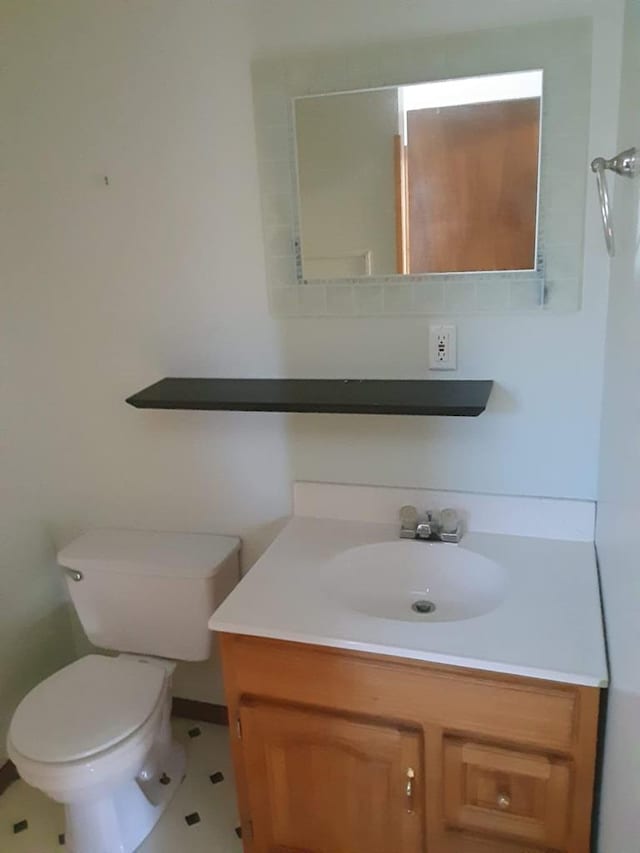 bathroom featuring tile patterned flooring, vanity, and toilet