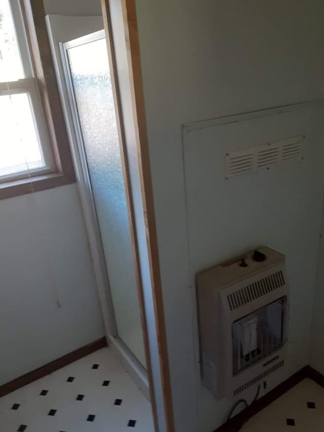 bathroom featuring heating unit and walk in shower