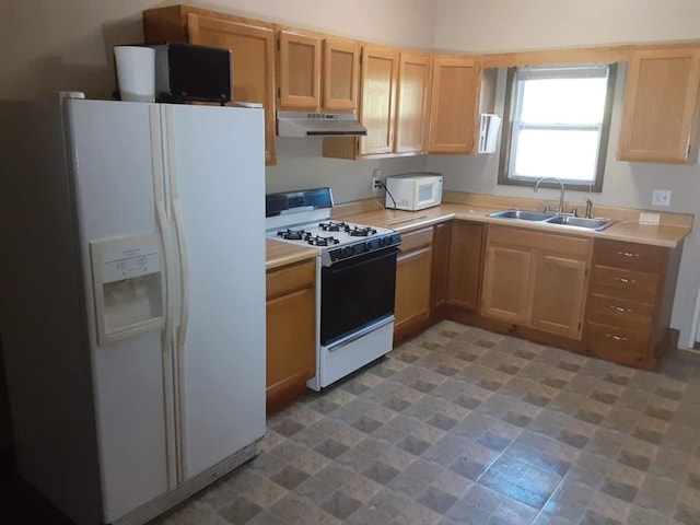 kitchen featuring white appliances, sink, and light brown cabinetry