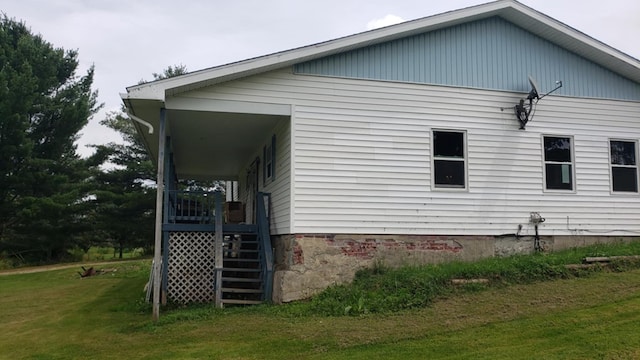 view of side of home featuring a porch and a yard