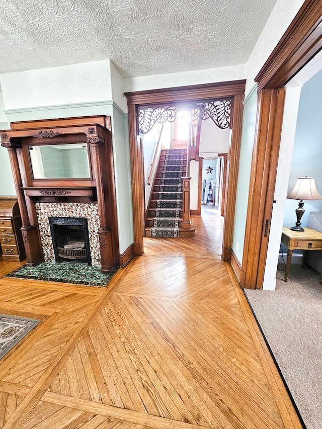 hallway with parquet flooring and a textured ceiling