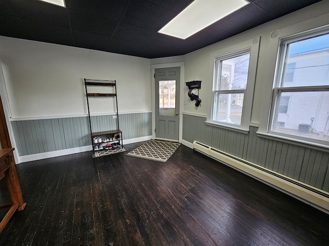 unfurnished room with wood-type flooring and a baseboard heating unit