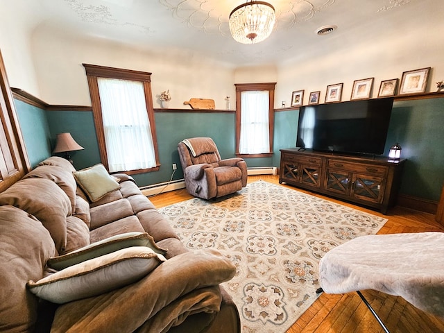 living room with light hardwood / wood-style flooring, an inviting chandelier, and a baseboard heating unit