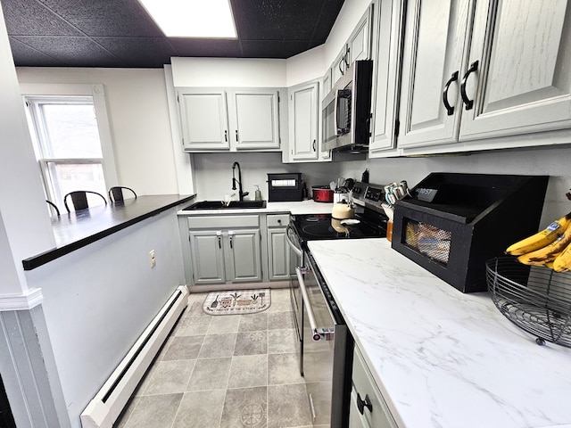 kitchen featuring sink, stainless steel appliances, a baseboard radiator, a paneled ceiling, and gray cabinets