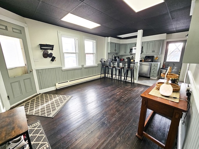 living room featuring a paneled ceiling, dark hardwood / wood-style flooring, and a baseboard radiator