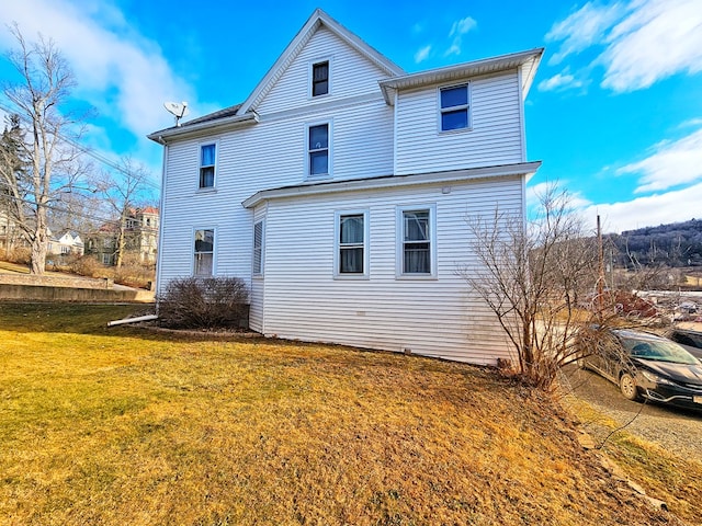 view of side of home with a yard