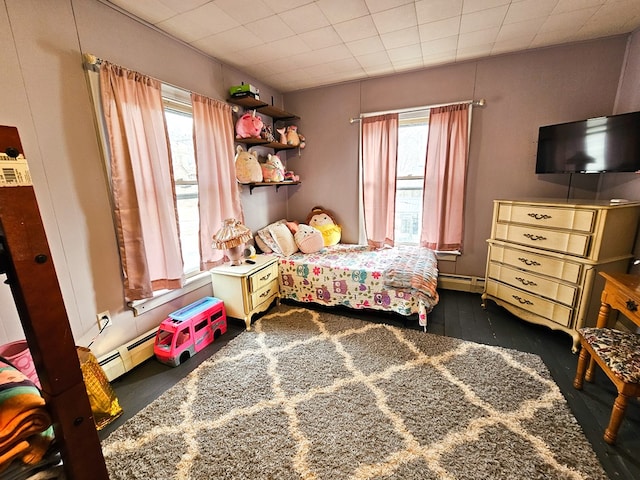 bedroom with multiple windows and baseboard heating