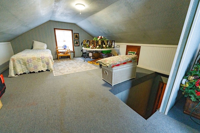 carpeted bedroom featuring vaulted ceiling and a textured ceiling