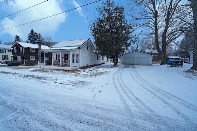 view of front of property featuring a porch, a garage, and an outbuilding