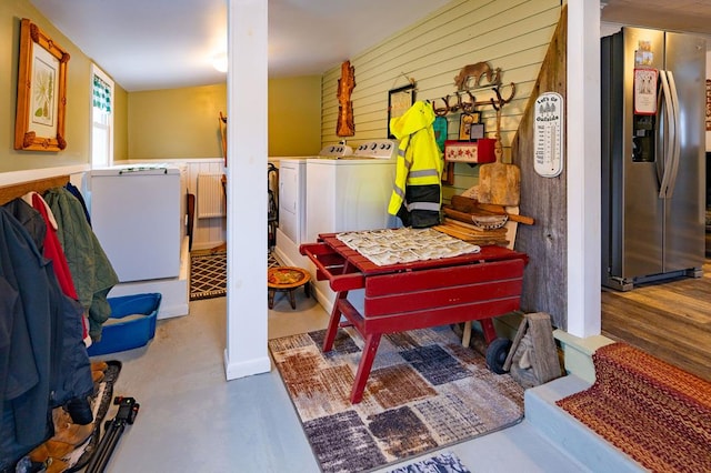 interior space with washer and clothes dryer and wooden walls