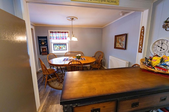 dining area with radiator heating unit, ornamental molding, and hardwood / wood-style floors