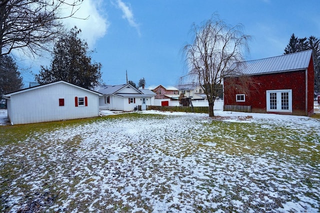 yard covered in snow featuring french doors