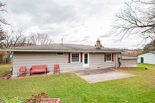 rear view of property featuring a lawn and a patio