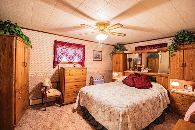 carpeted bedroom with a baseboard radiator, ceiling fan, and crown molding