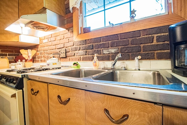 kitchen with sink, white stove, range hood, and brick wall