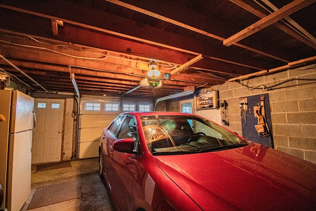 garage featuring a garage door opener and white refrigerator