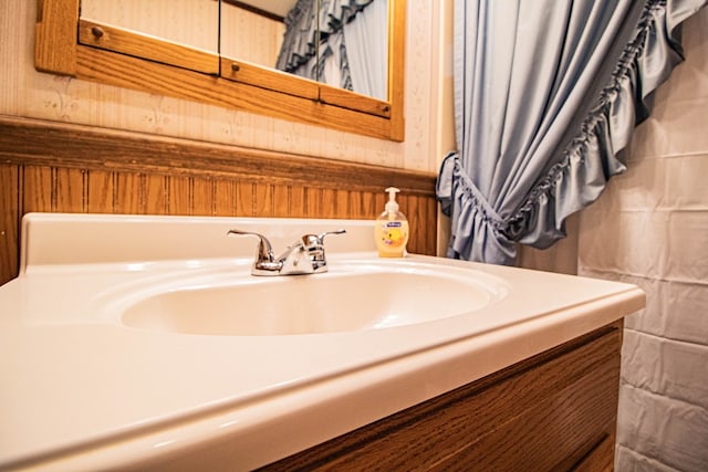 bathroom with vanity and wood walls