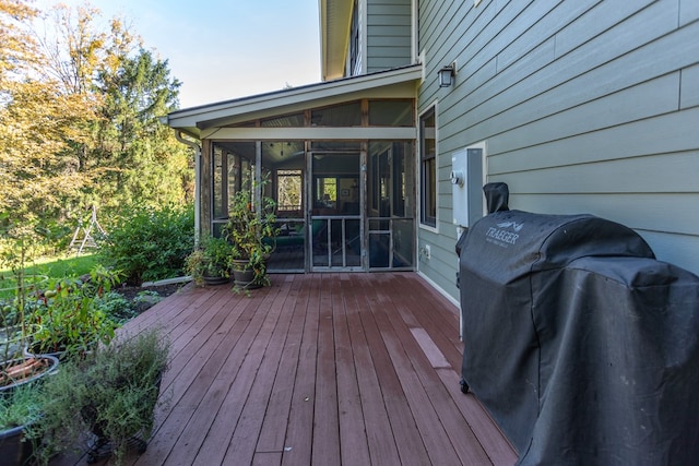 deck with grilling area and a sunroom