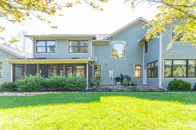 view of front of home featuring a sunroom, a patio area, and a front yard