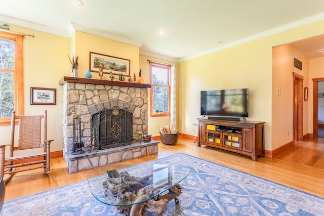 living room featuring a fireplace, hardwood / wood-style flooring, a wealth of natural light, and ornamental molding