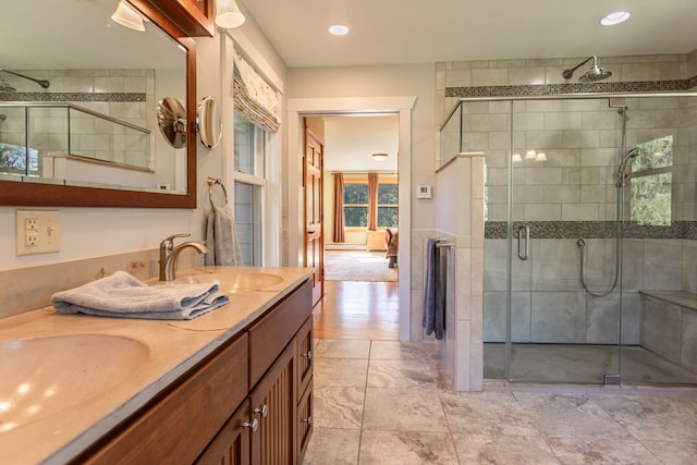 bathroom with vanity and a shower with door