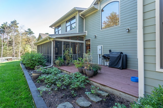 rear view of house featuring a sunroom, a deck, and a yard