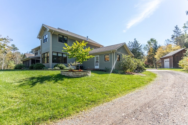 view of front of home with a front lawn and an outdoor structure