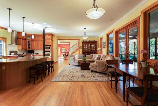 living room featuring light wood-type flooring, ornamental molding, and french doors