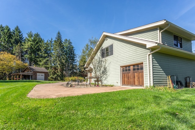 view of property exterior featuring a lawn, a garage, and a patio