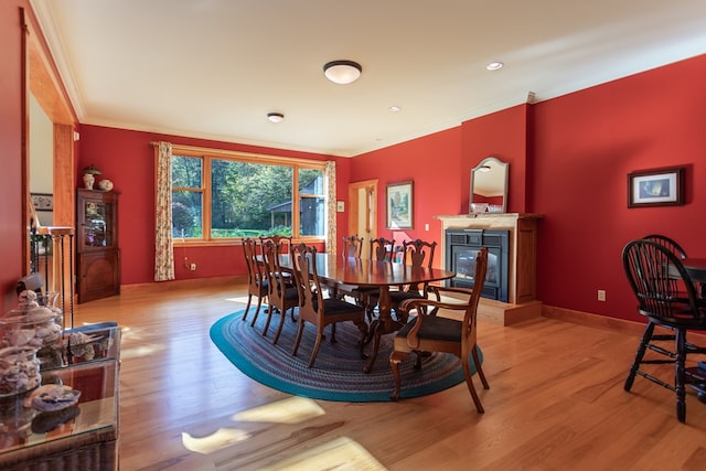 dining room with light hardwood / wood-style floors and crown molding