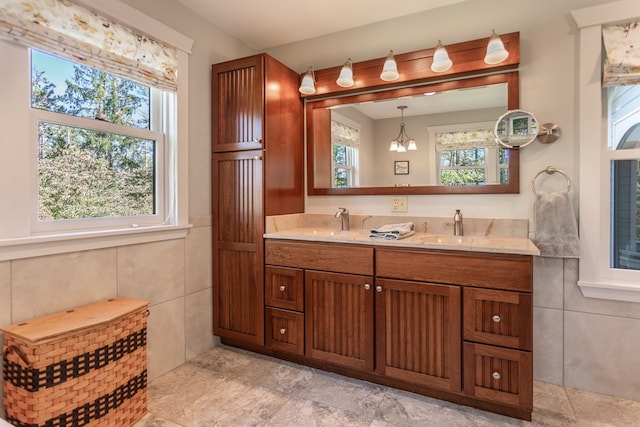 bathroom featuring vanity, tile walls, and an inviting chandelier