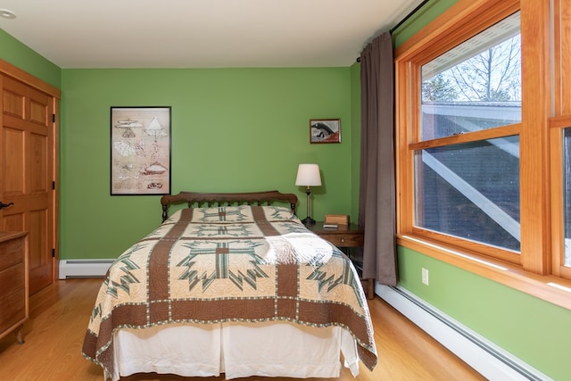 bedroom featuring a baseboard radiator and light hardwood / wood-style floors