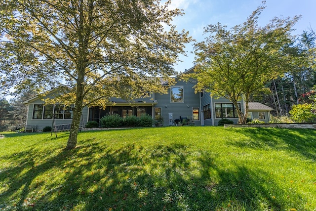 rear view of house featuring a lawn