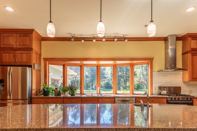 kitchen with decorative backsplash, decorative light fixtures, stainless steel appliances, and wall chimney exhaust hood