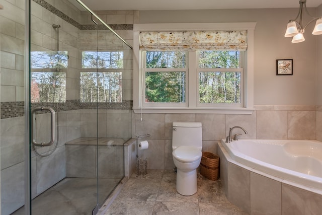 bathroom with a chandelier, shower with separate bathtub, and toilet