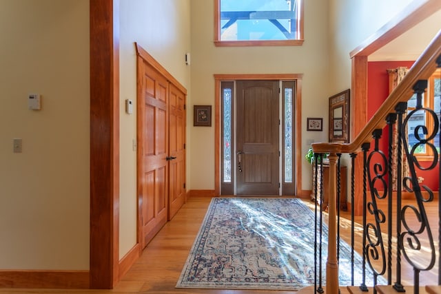 entrance foyer featuring light hardwood / wood-style flooring and a high ceiling