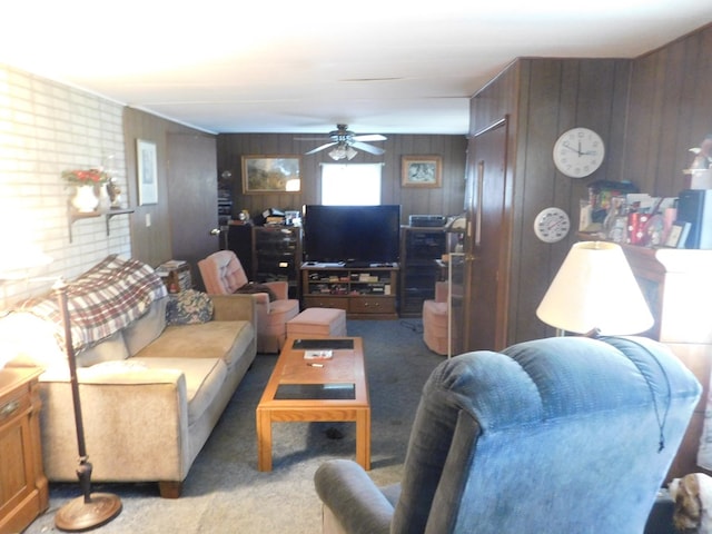 living room featuring carpet, ceiling fan, and wooden walls