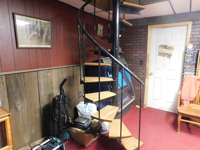 staircase featuring wooden walls