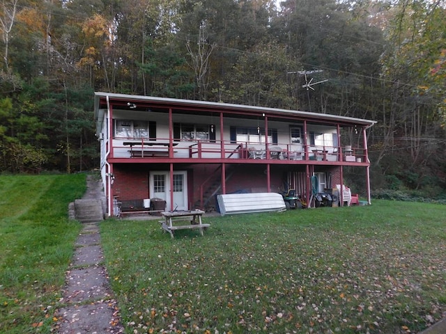 rear view of house with a lawn and a wooden deck