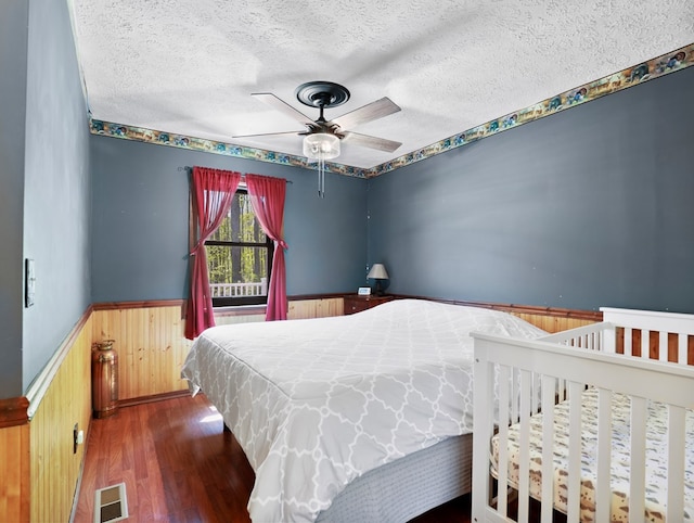 543 Drybrook Rd, Waverly, NY 14892 - bedroom featuring a wainscoted wall, wood finished floors, a textured ceiling, wood walls, and ceiling fan